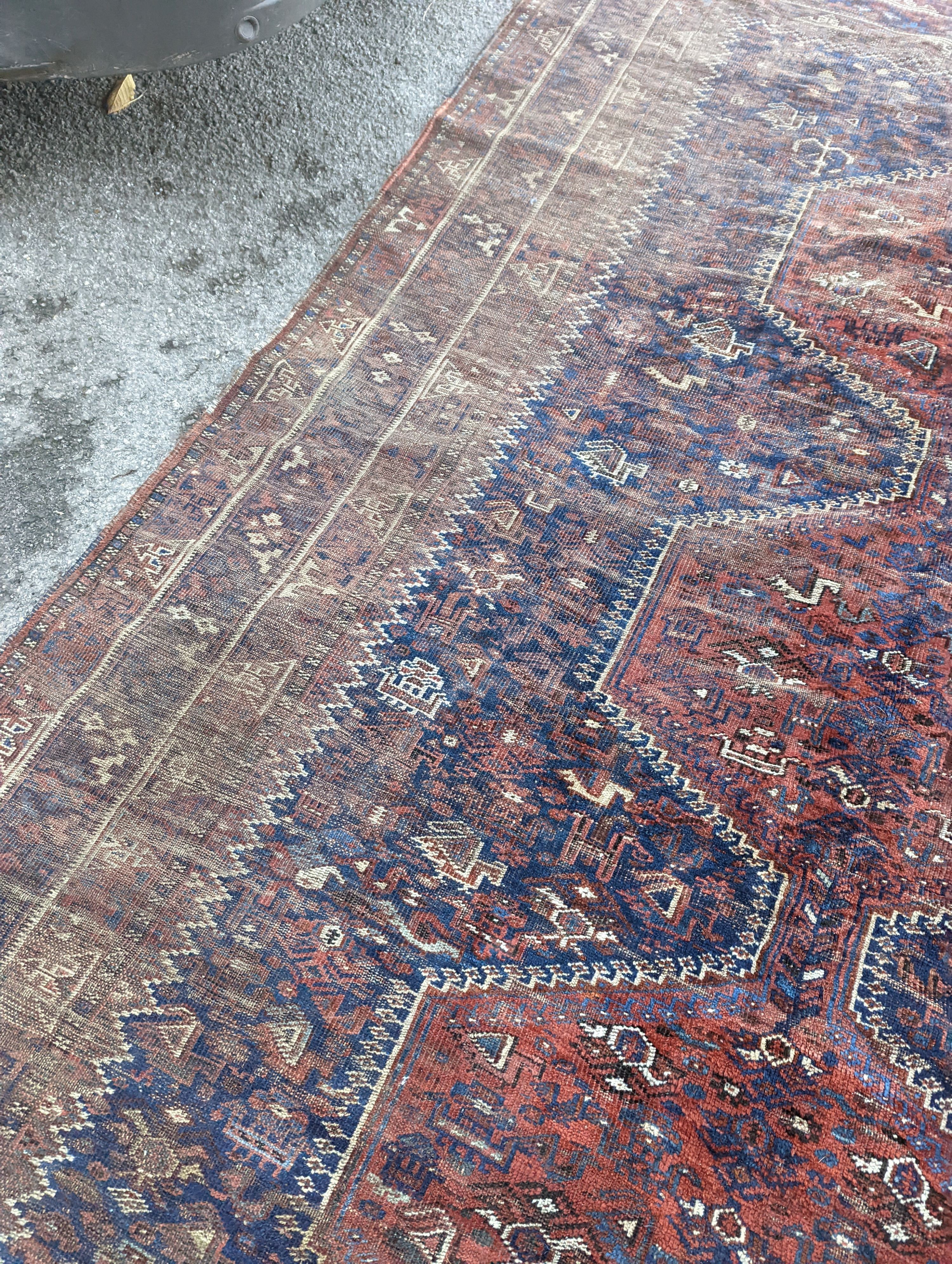 An antique Shirvan red ground carpet (worn), 295 x 207cm